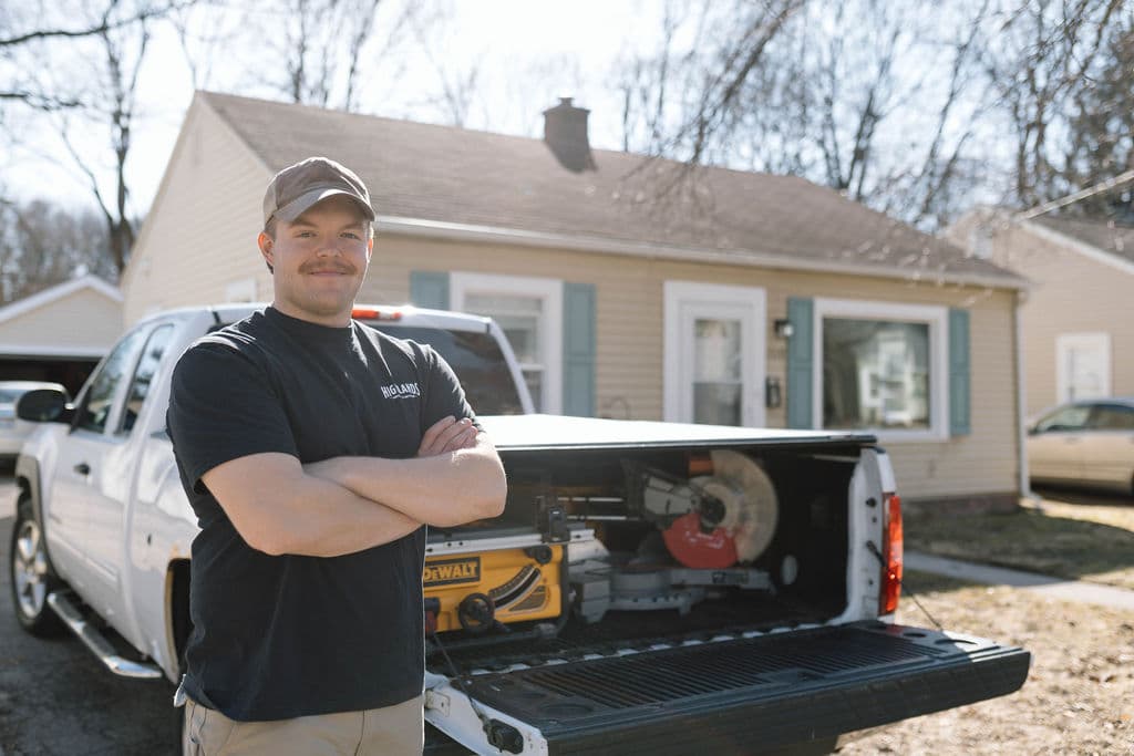 Adam Ginn beside a work truck loaded with carpentry tools