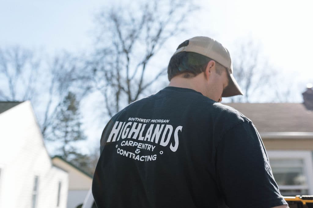 Highlands Carpentry logo on the back of Adam's work shirt