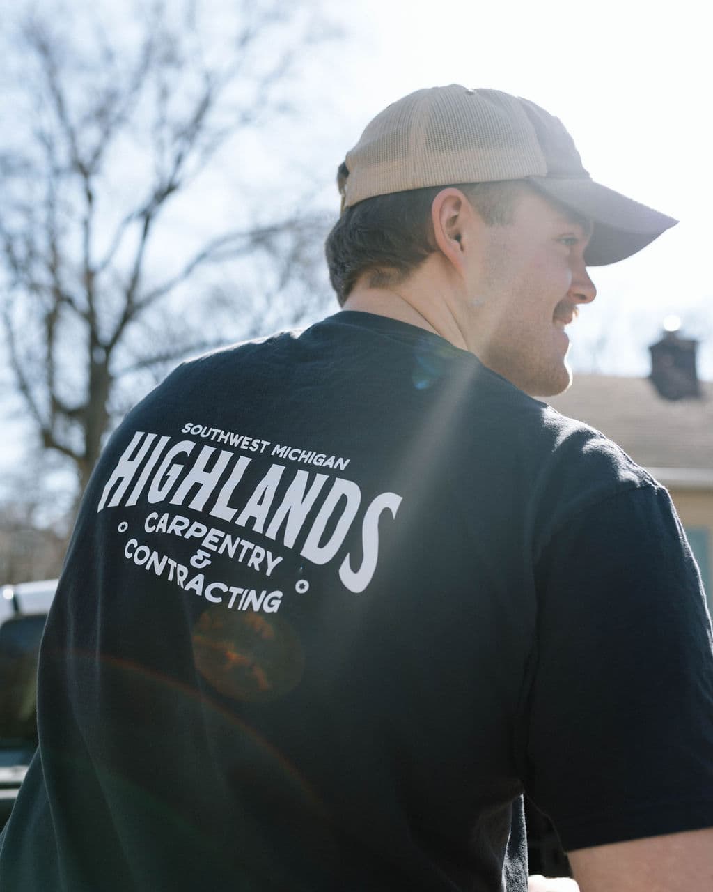 Adam wearing a Highlands Carpentry work shirt outdoors