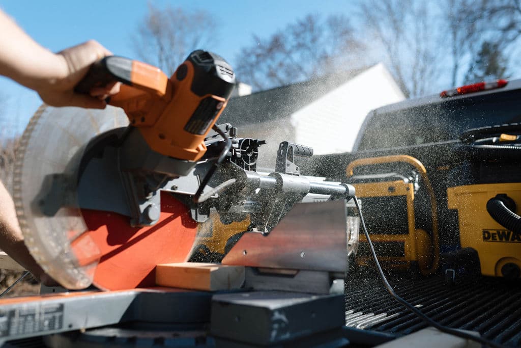 Miter saw cutting lumber at an outdoor jobsite