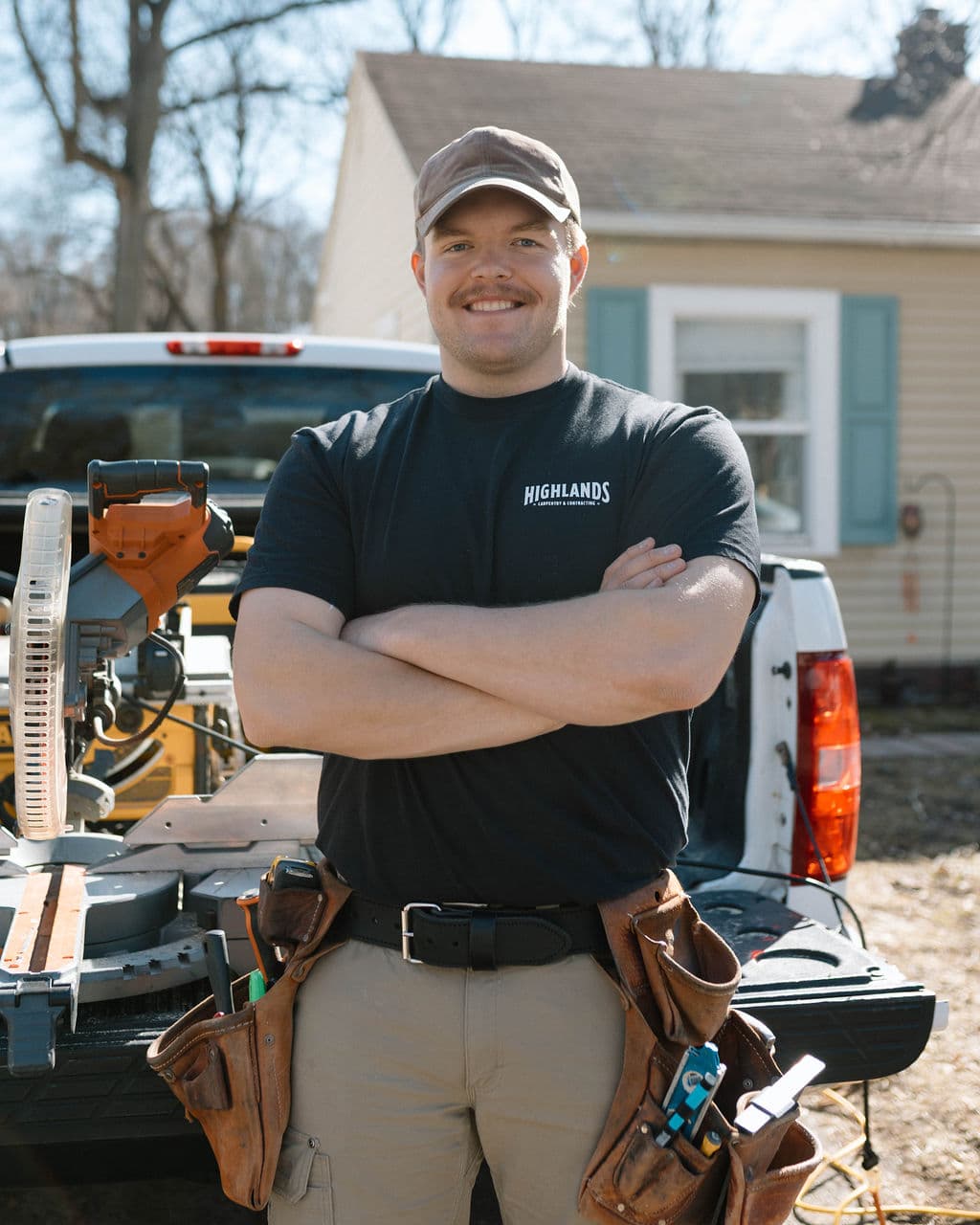 Portrait of Adam Ginn with his carpentry tools and work truck