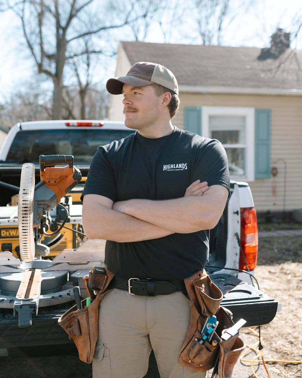 Adam Ginn in a tool belt looking across an outdoor jobsite