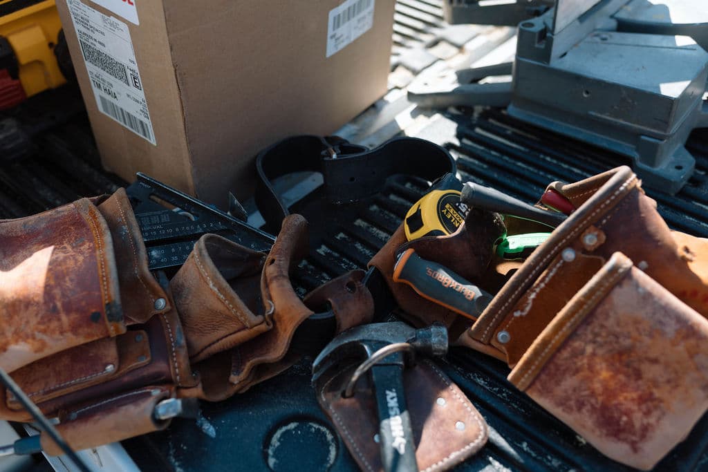 Carpentry tool belts and measuring tools arranged in a truck bed